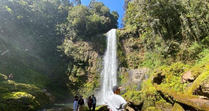Pemandangan Air Terjun Sarambu Tonapa di Toraja Utara dengan tebing batu, air jernih, dan hutan hijau yang masih alami.